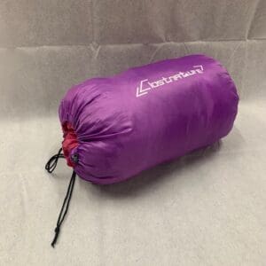 A purple sleeping bag on the ground.