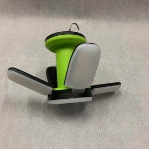 A green and white phone holder sitting on top of a table.