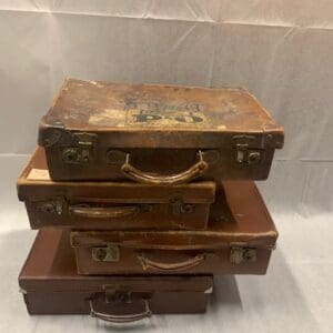 A stack of four old suitcases on top of each other.