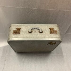 A silver suitcase sitting on top of the floor.