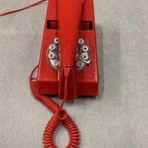 A red phone with an extension cord attached to it.