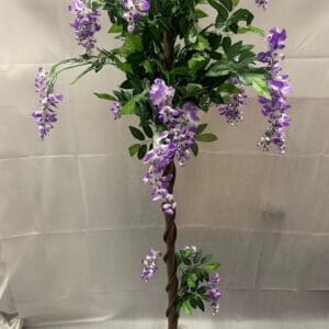 A tall tree with purple flowers on top of it.