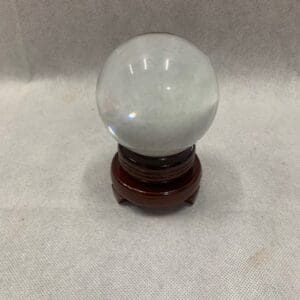 A small glass ball on a wooden stand.