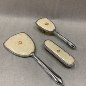 A set of three vintage hair brushes and mirror.