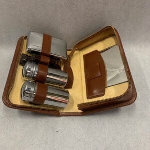 A brown leather case with three batteries and two cigarette packs.