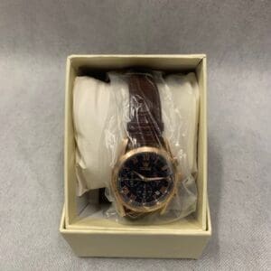 A watch in its box with the strap still attached.