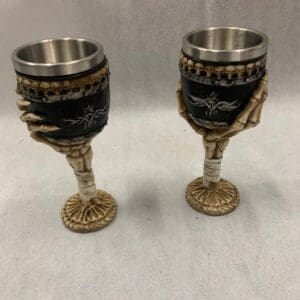 A pair of wine glasses with gold and black designs.