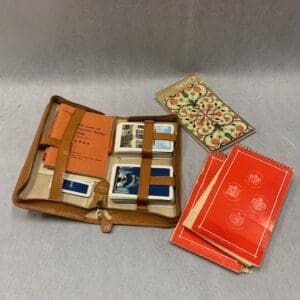 A brown leather case with several cards and two red cases.