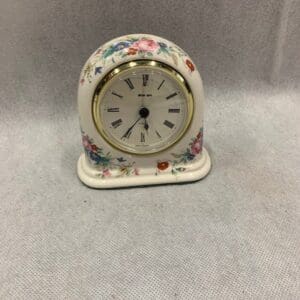 A small clock sitting on top of a table.