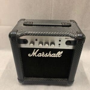 A black and silver marshall guitar amp sitting on top of a table.