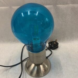 A blue lamp sitting on top of a table.