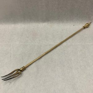 A fork with a wooden handle and gold colored handles.