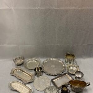 A table with many silver plates and bowls