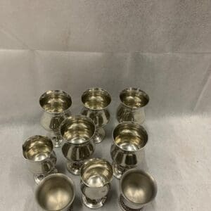 A group of silver cups sitting on top of a table.