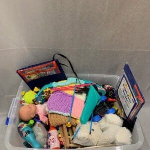 A bin of toys and other items in the bathroom.