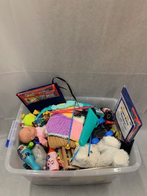 A bin of toys and other items in the bathroom.