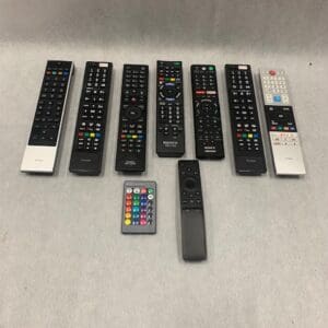 A group of remote controls sitting on top of a table.