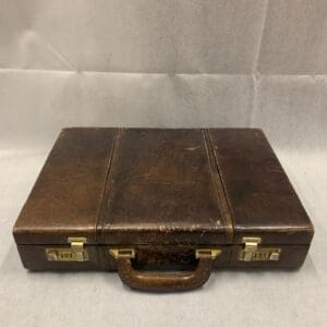 A brown leather briefcase sitting on top of a table.