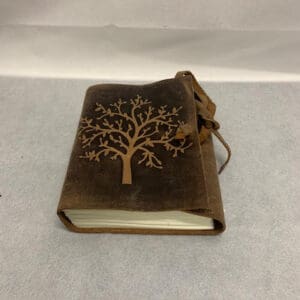 A brown book with an image of a tree on it.