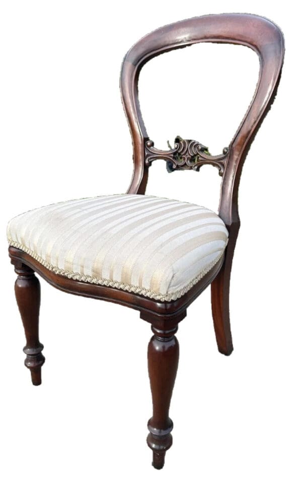 A chair with white seat and wooden legs.