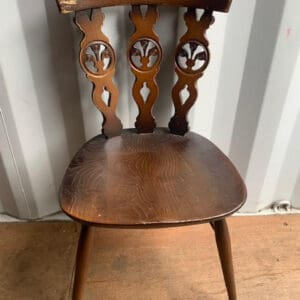 A wooden chair sitting in front of a wall.