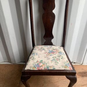 A chair with a floral seat cushion on it.