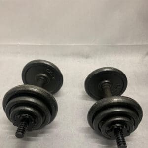 Two black dumbbells sitting on top of a white surface.