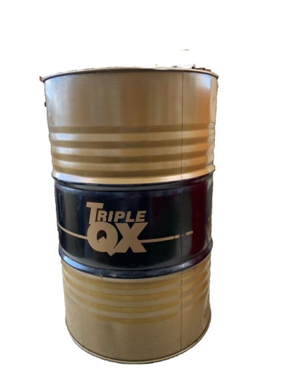 A barrel of triple qx oil sitting on top of a table.