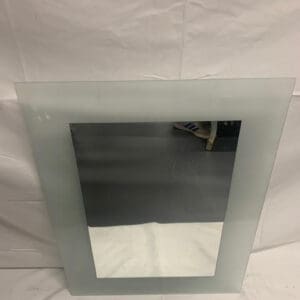 A mirror with a glass frame on it.