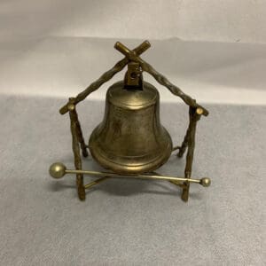 A bell sitting on top of a metal stand.