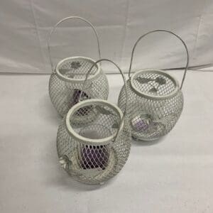 Three white metal candle holders.