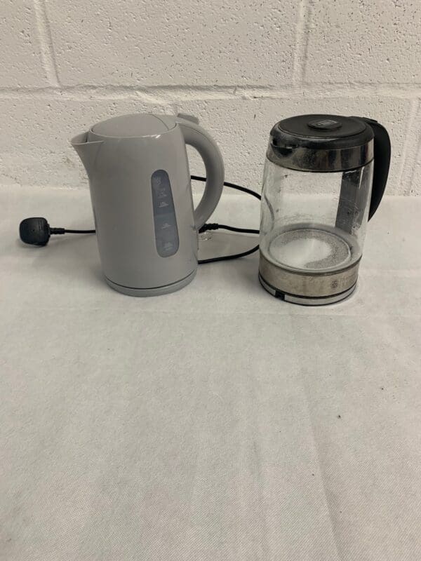 Two electric kettles, gray and glass.