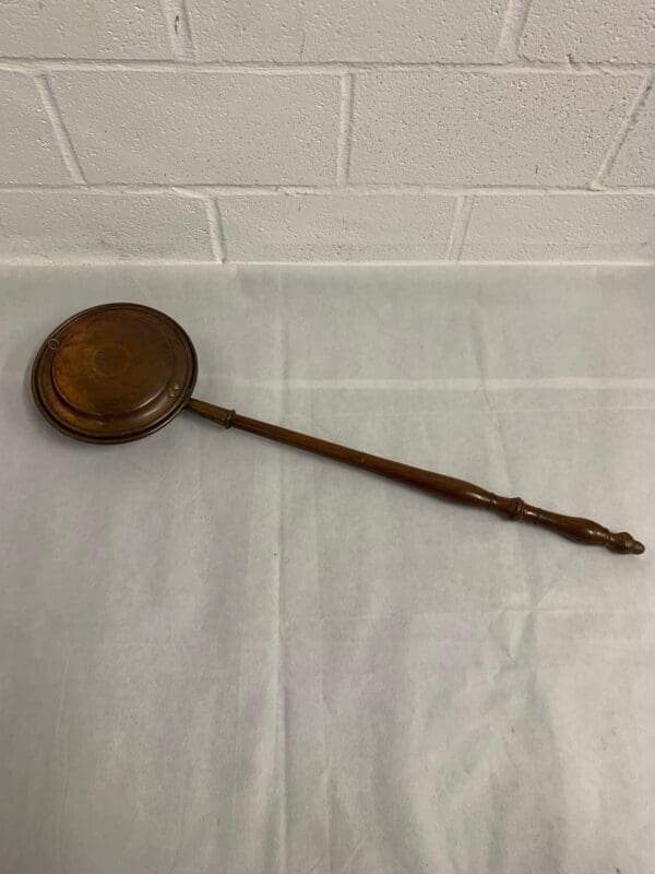 Antique copper warming pan with wood handle.